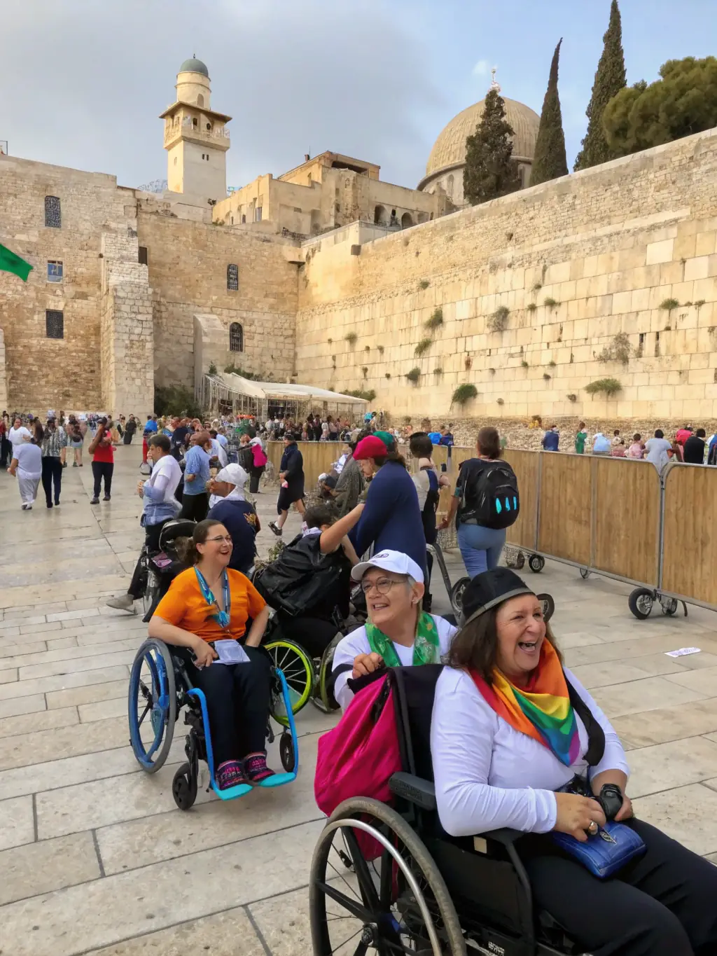 A group of travelers with mobility challenges exploring the ancient city of Caesarea, with accessible pathways and transportation options clearly visible.